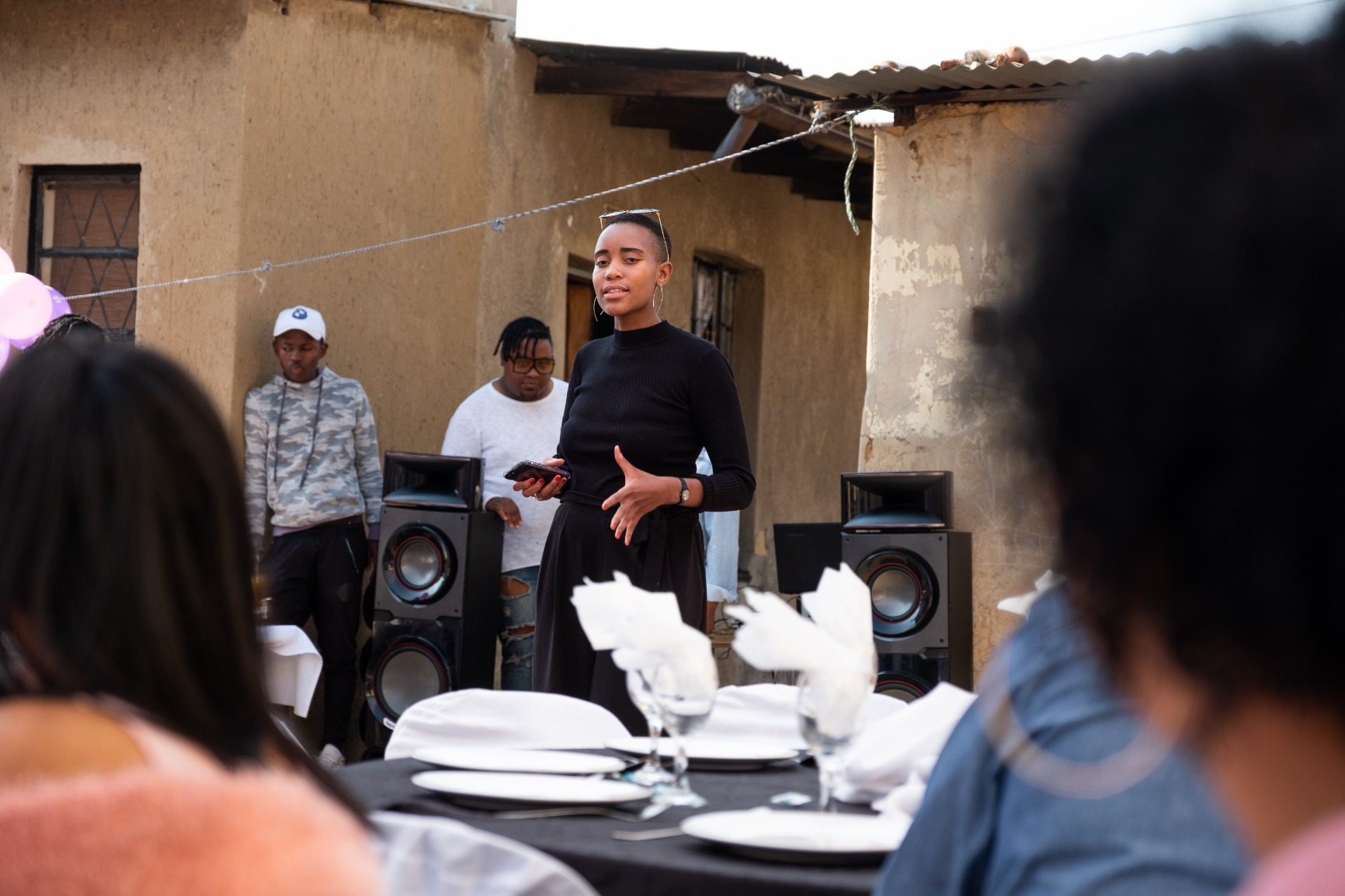Photo of Khensani Jurczok-de Klerk standing in the couryard giving a talk for the event.